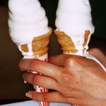 Mains tenant des glaces colorées pour illustrer l’histoire sensorielle du parfum.